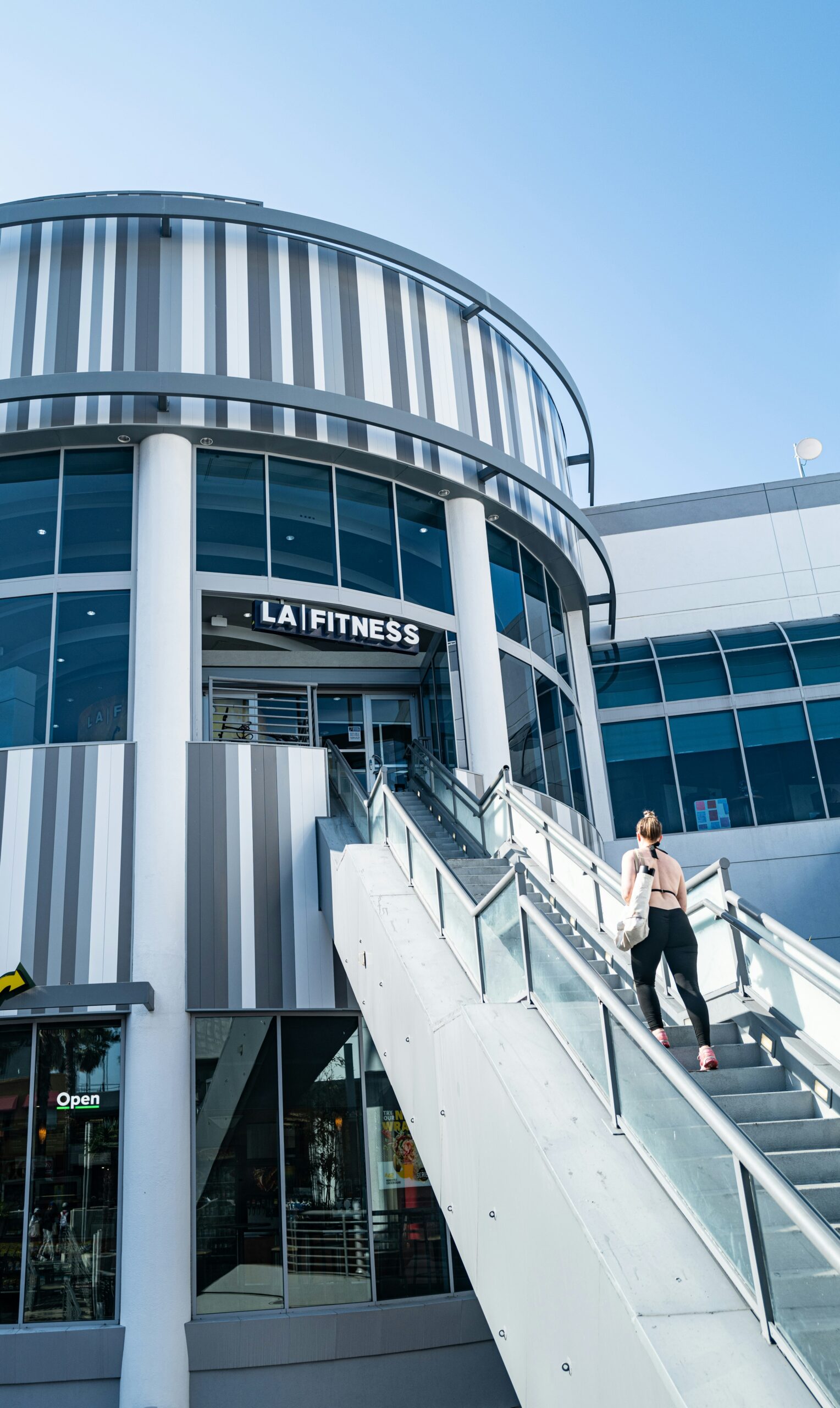 a woman walking down a set of stairs in front of a building